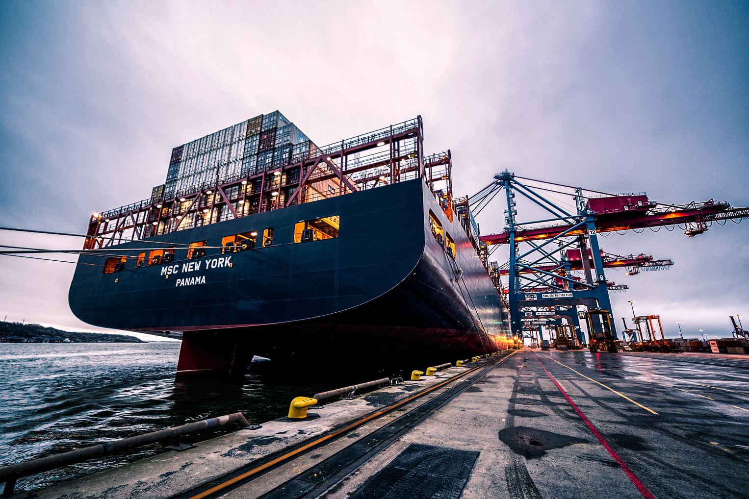 Container ship docked at a terminal with cranes